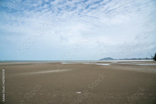 The sea at low tide reveals a wide expanse of sand.