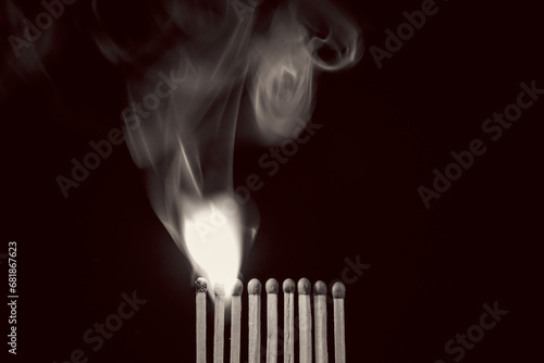 Photography Ignited Matches besides a row of unlit matches