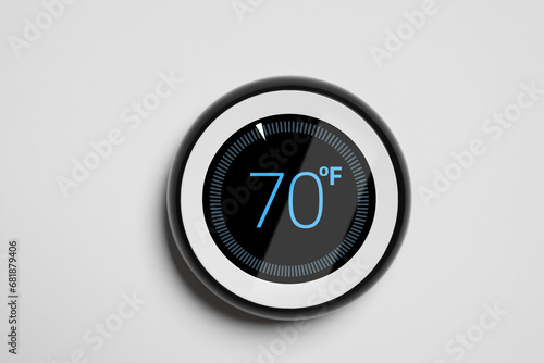 Thermostat displaying temperature in Fahrenheit scale. Smart home device on white wall