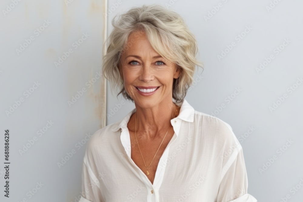 Portrait of a happy senior woman smiling at the camera while leaning against a wall Portrait of a happy senior woman smiling at the camera while leaning against a wall