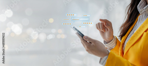 A young woman is rating the service she received on her smartphone, The customer gave five stars to the product she received with complete satisfaction. photo