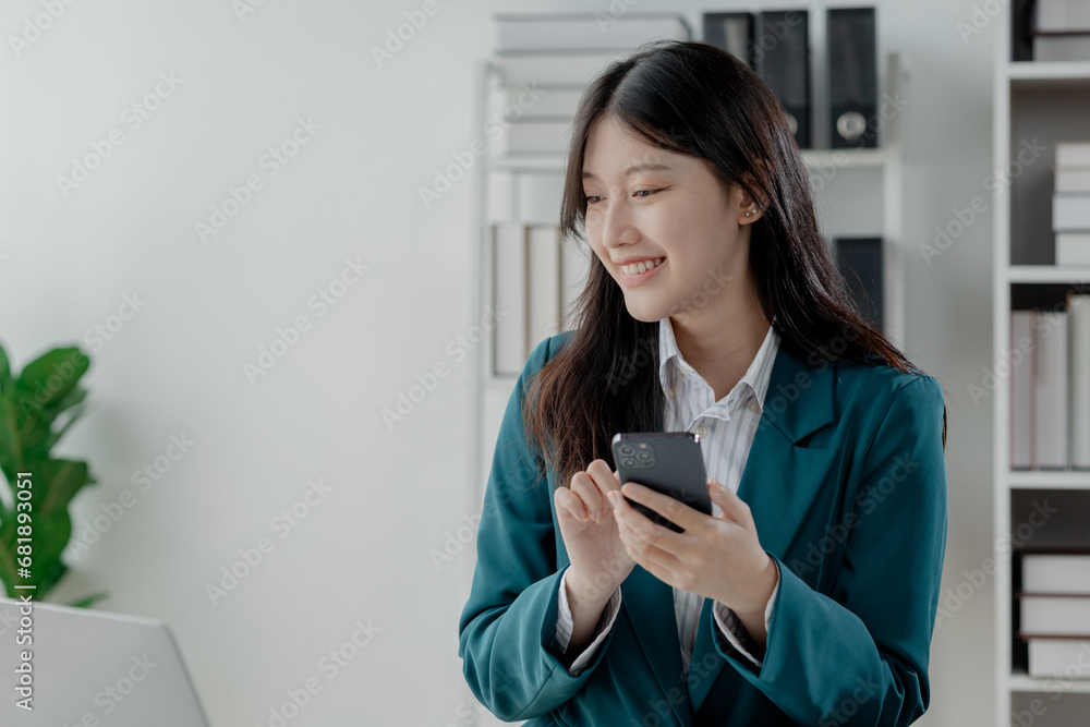 Businesswoman is working in the office and talking on the phone with a partner, Entrepreneurs use smartphones to find information in order to present it, Working in a private office at a company. Businesswoman is working in the office and talking on the phone with a partner, Entrepreneurs use smartphones to find information in order to present it, Working in a private office at a company.