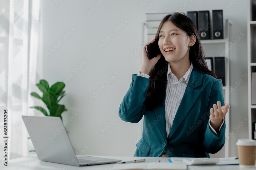 Businesswoman is working in the office and talking on the phone with a partner, Entrepreneurs use smartphones to find information in order to present it, Working in a private office at a company. Businesswoman is working in the office and talking on the phone with a partner, Entrepreneurs use smartphones to find information in order to present it, Working in a private office at a company.