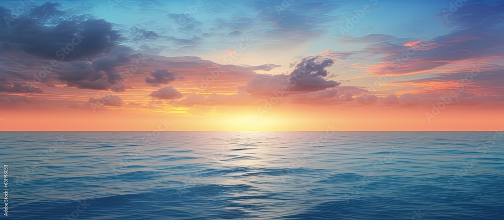 As the sun sets below the horizon, casting a warm glow across the vast expanse of sky and sea, the breathtaking landscape emerges - a beautiful symphony of water and nature in hues of blue and gold.