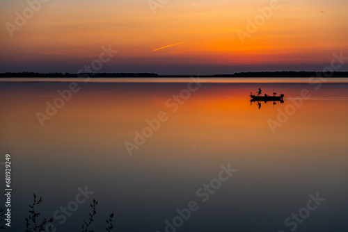Canvas-taulu Fishing Boat on Colorful Reflective Lake in Evening Twilight
