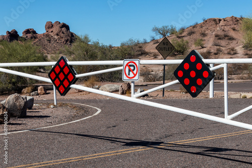 No parking sign on the road with white gate in desert landscape environment photo