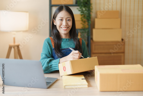 Starting small business entrepreneur of independent Asian female online seller packing products to send to customers and SME delivery concept