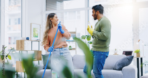 Couple, home and cleaning with singing, broom and comic performance in living room, hygiene and teamwork. Man, woman and happy with funny dancing, concert or game with help for dirt, dust or bacteria