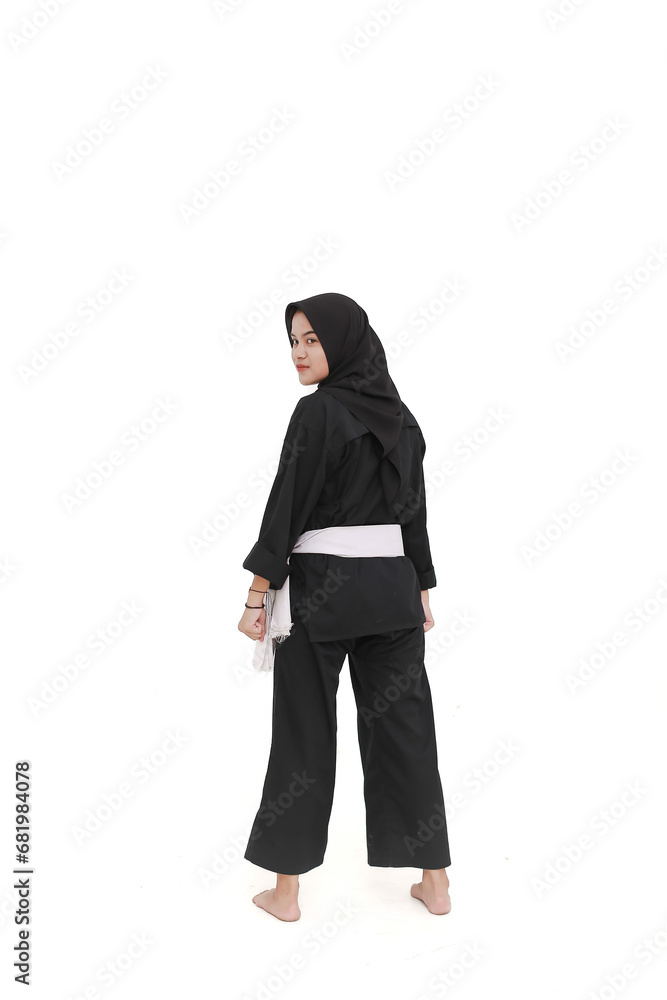 Asian women in hijabs wearing pencak silat uniforms with white belts perform stance movements on the isolated background Asian women in hijabs wearing pencak silat uniforms with white belts perform stance movements on the isolated background