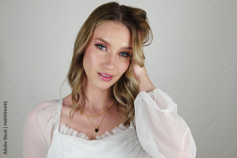 Fototapeta premium Captivating Blue Eyes and Brunette Beauty: Allure in White Shirt with Black and Gold Necklace
