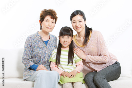 ソファーに座る三世代家族 © UTS