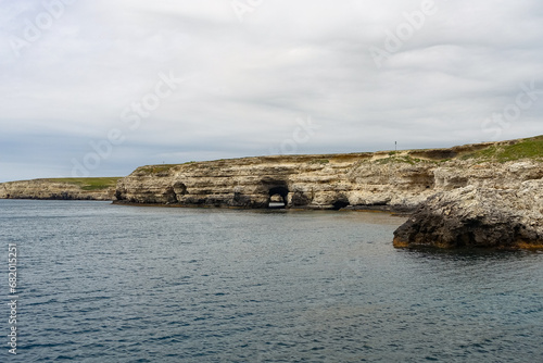 Cape Tarkhankut on the Crimean peninsula. The rocky coast of the Dzhangul Reserve in the Crimea. The Black Sea. Turquoise sea water. Rocks and grottoes of Cape Tarkhankut. photo