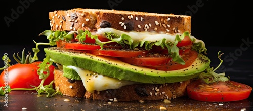 background, a hearty and healthy breakfast sandwich with avocado, tomato, and chia seeds was being prepared, making it a tasty and satisfying snack. The bread was toasted to perfection, and a generous