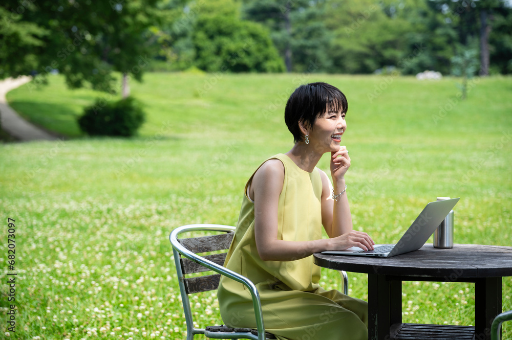 Young Asian businesswoman c working outdoors on her laptop in an outdoor cafe.female entrepreneur running her own business. Business lifestyle and technology Young Asian businesswoman c working outdoors on her laptop in an outdoor cafe.female entrepreneur running her own business. Business lifestyle and technology