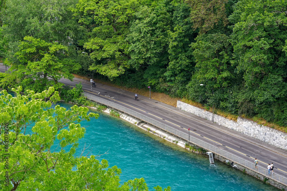 Scenic aerial view of Aare River with trees alongside urban road at Swiss City of Bern a cloudy summer day. Photo taken July 1st, 2023, Bern, Switzerland.