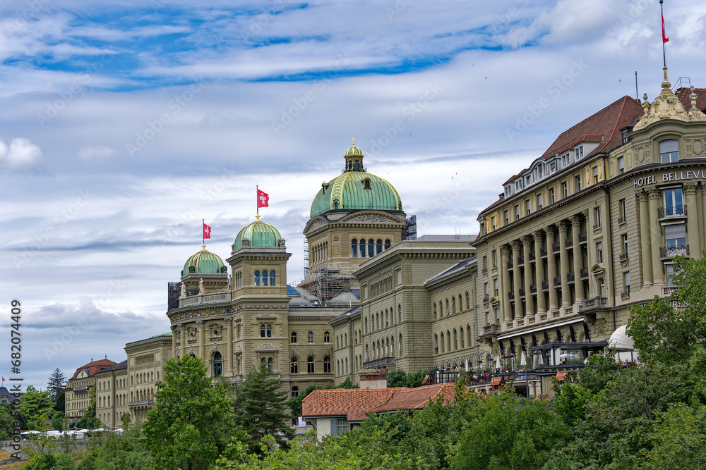 Towers with green copper domes of Swiss Federal Palace on a cloudy summer day at Bern, Capital of Switzerland. Photo taken July 1st, 2023, Bern, Switzerland.