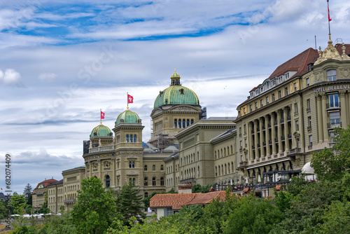 Towers with green copper domes of Swiss Federal Palace on a cloudy summer day at Bern, Capital of Switzerland. Photo taken July 1st, 2023, Bern, Switzerland.