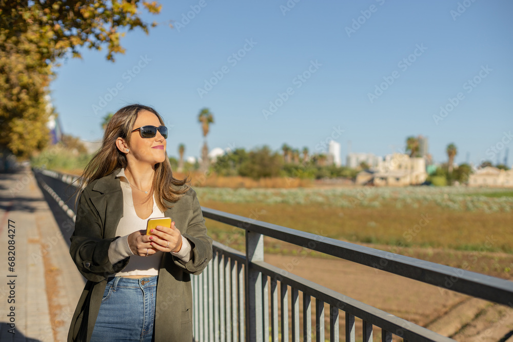 young woman walking down the street talking on the phone