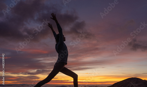 Silhouette of woman doing a yoga pose at sunset