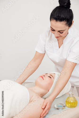 Female masseur doing therapeutic facial massage in spa
