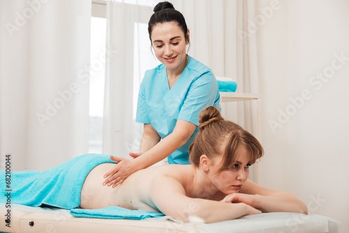Masseuse doing a therapeutic relaxing back massage