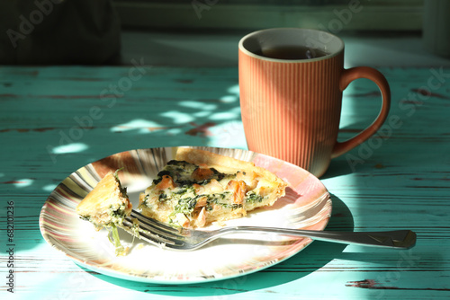Delicious Quiche pie with salmon fish and pine nuts filling. Breakfast with quiche and cup of coffee