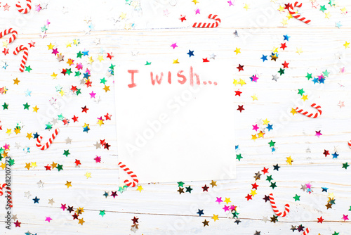 notebook with wish list on vintage wooden table with candy canes. christmas planning concept.