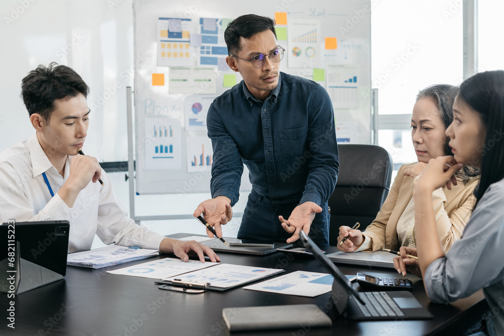 Group of Asian business people, teamwork, people and crisis concept - business team sitting sad and solving problems in the office. Group of Asian business people, teamwork, people and crisis concept - business team sitting sad and solving problems in the office.