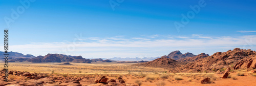 Vast desert landscape with rocky formations under a blue sky