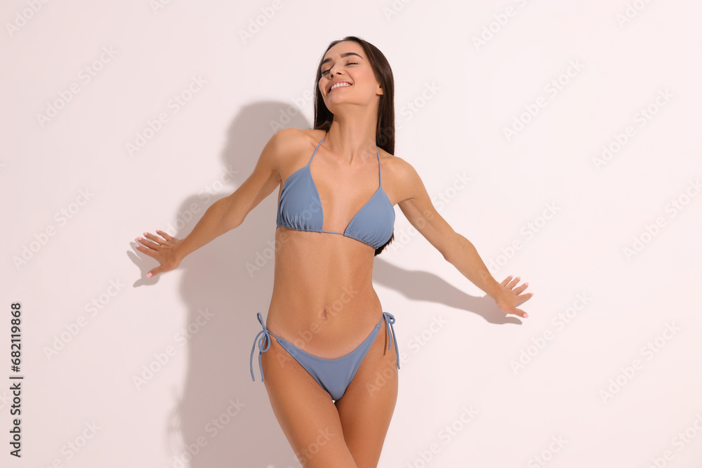 Naklejka premium Young woman in stylish bikini on white background