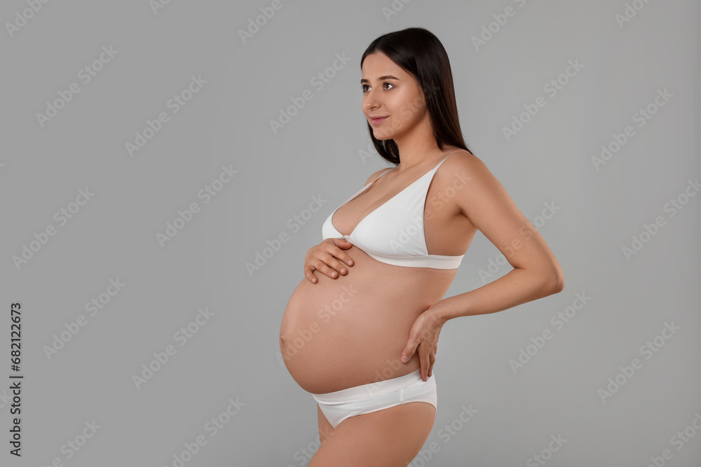 Beautiful pregnant woman in stylish comfortable underwear on grey background, space for text Beautiful pregnant woman in stylish comfortable underwear on grey background, space for text