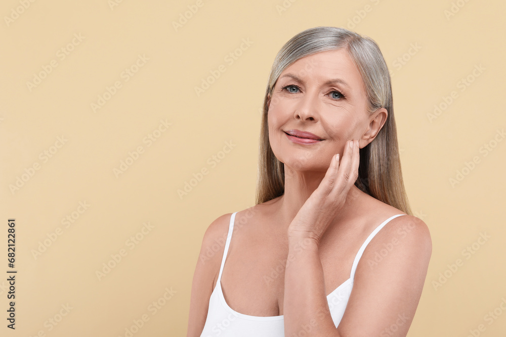 Portrait of beautiful senior woman on beige background. Space for text Portrait of beautiful senior woman on beige background. Space for text