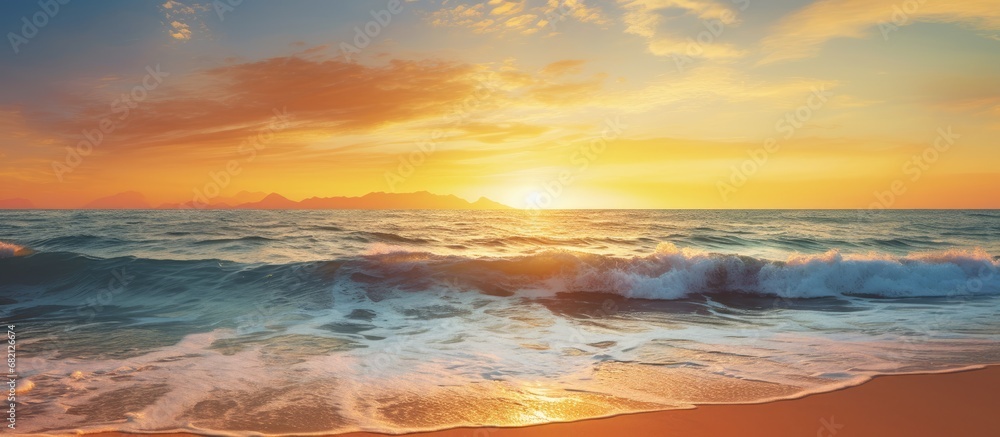 As the golden sun descends behind the tranquil ocean, a mesmerizing blend of vibrant hues paints the sky, casting a captivating silhouette upon the tropical beach, enveloped by the summer breeze and