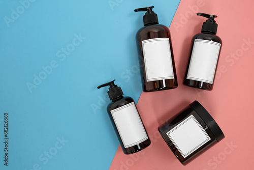 Body care. set of bottles with dispensers and jars of body cream on a blue and pink background. Advertising concept