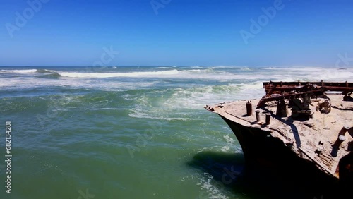 Rusted old shipwreck battered by waves on Cape Agulhas coastline, aerial