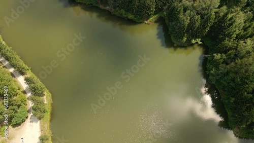 Ascending drone footage captures the lake Radalj in Serbia and surrounding forest photo