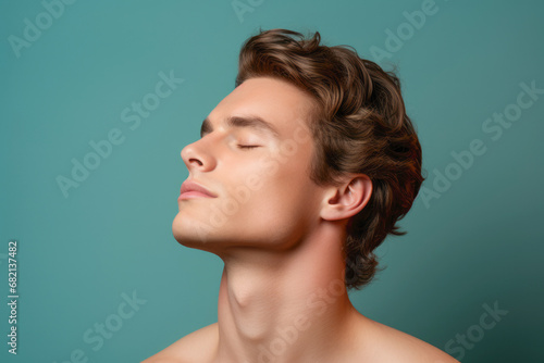 A sexy and healthy young man, with a closeup focus on his head and chin, exudes a serious yet attractive expression, emphasizing the care and attention to detail in his appearance. photo