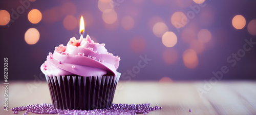 Birthday purple cupcake with candle on light purple boke photo
