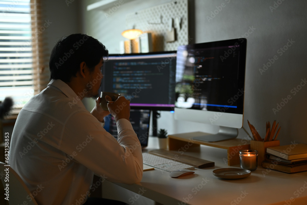 Concentrated young professionals working in software development in dark office Concentrated young professionals working in software development in dark office