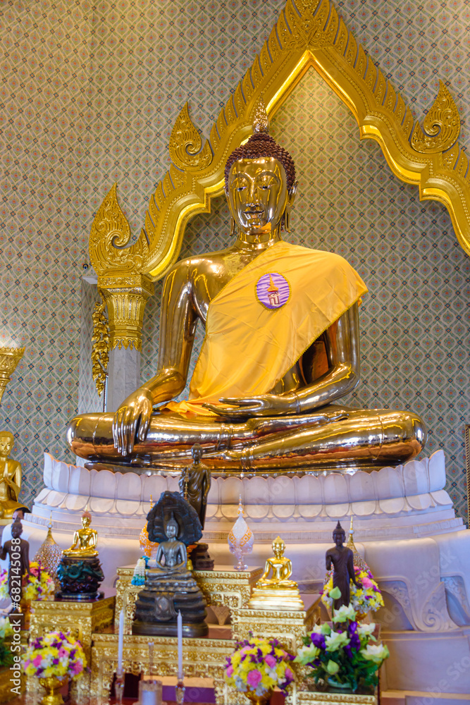 Fototapeta premium Golden statue of Buddha with a saffron robe and shrine, Wat Songkhram, Bangkok, Thailand
