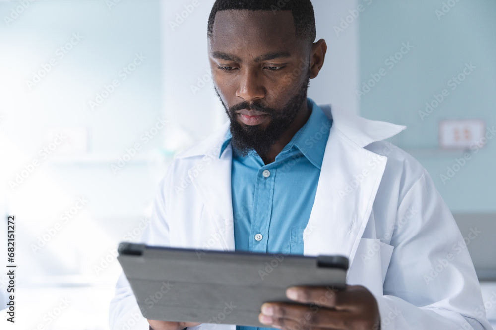 African american male doctor using tablet in hospital room African american male doctor using tablet in hospital room