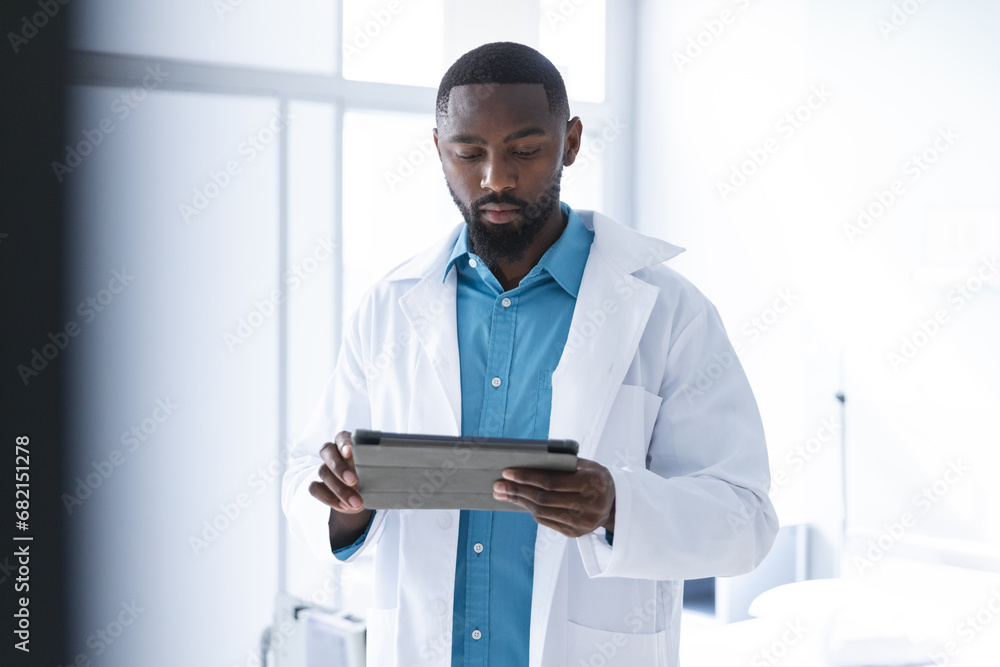 African american male doctor using tablet in hospital room African american male doctor using tablet in hospital room