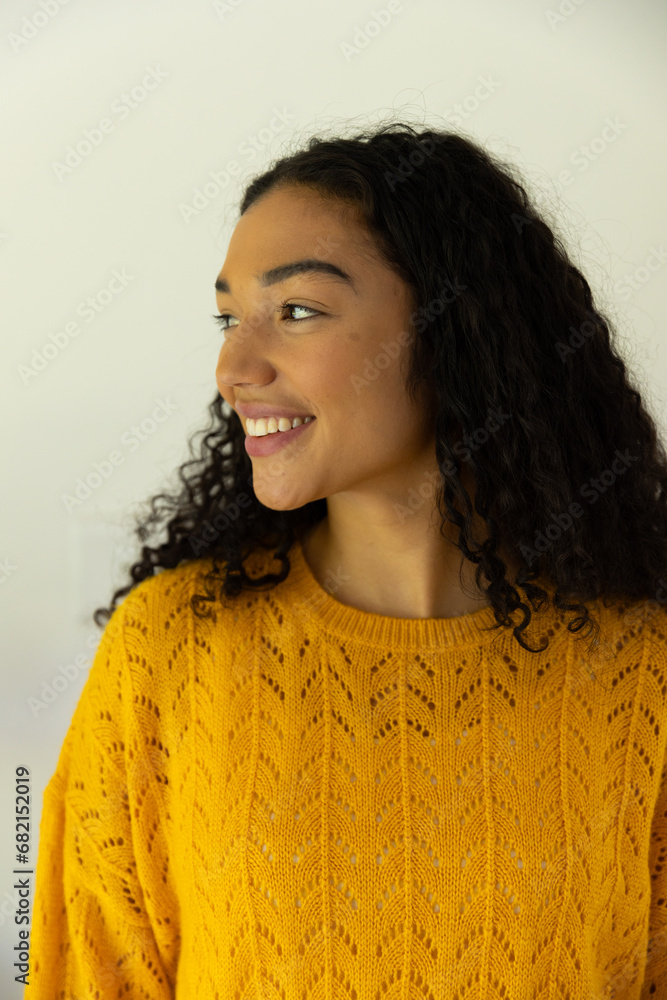 Profile of happy biracial woman in yellow sweater at home Profile of happy biracial woman in yellow sweater at home