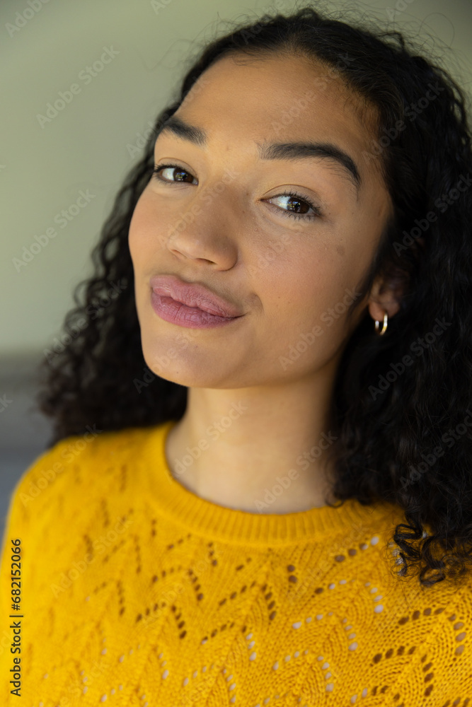 Close up portrait of biracial woman in yellow sweater at home Close up portrait of biracial woman in yellow sweater at home