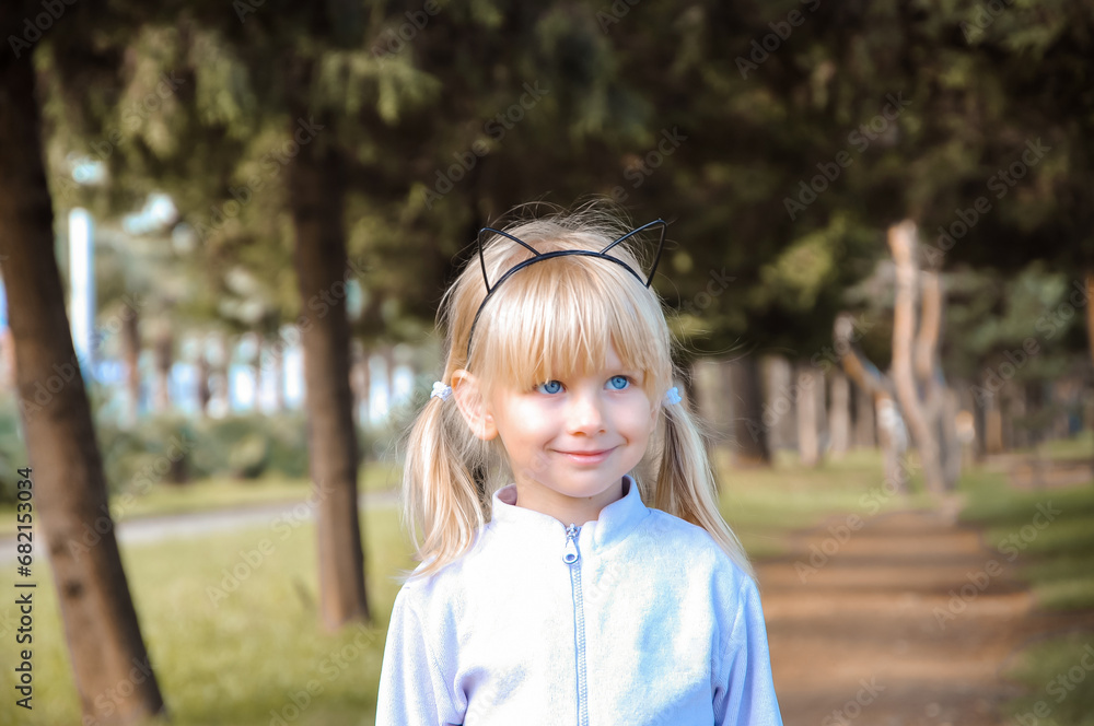 Girl with blue eyes in the park. Blonde child. Girl with blue eyes in the park. Blonde child.