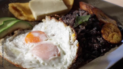 Balanced, healthy, Costa Rican traditional full breakfast with fried eggs, avocado, rice and beans, tortilla and cheese.