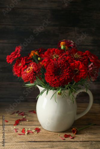 Bouquet of beautiful wild flowers on wooden table against black background