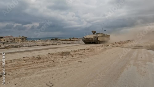 Israeli Namer APC speeds along the Mediterranean coastline in the Gaza strip photo