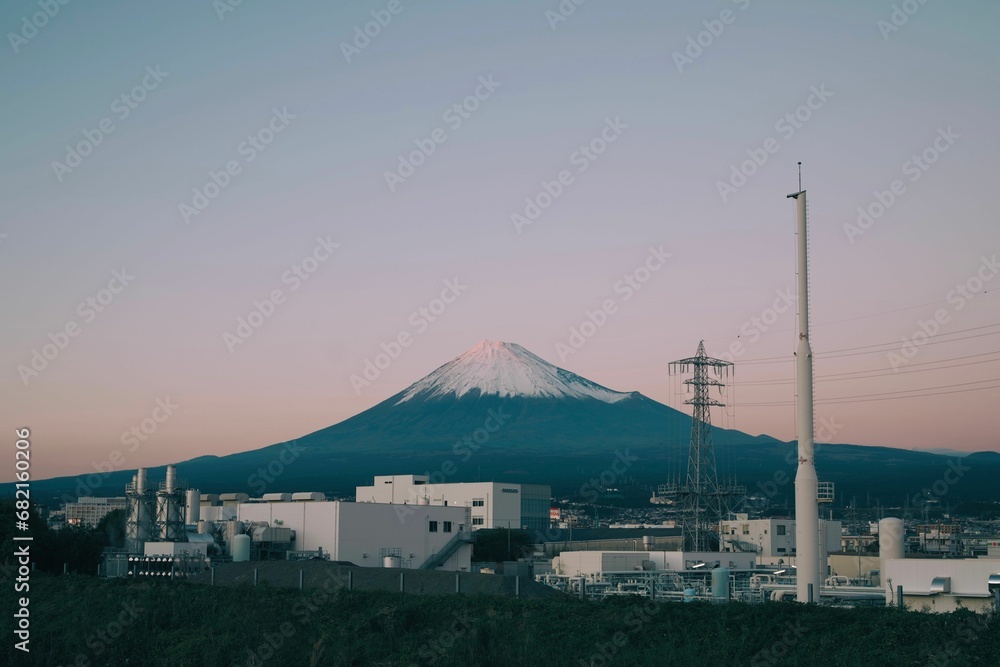 Awe-inspiring view of Mount Fuji, the mountain's silhouette against a sunset sky over a cityscape