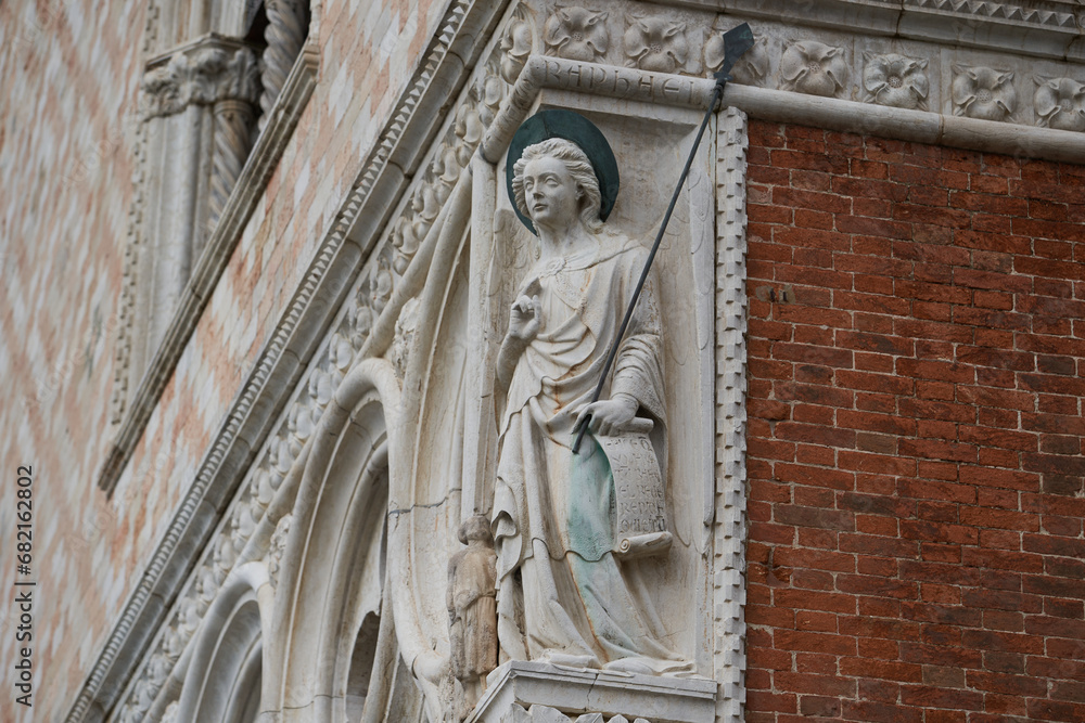 Statue of archangel Raphael wit a spear on the exterior of the Doge's Palace (Italian: Palazzo Ducale), one of the main Venetian landmarks. Venice - 5 May, 2019